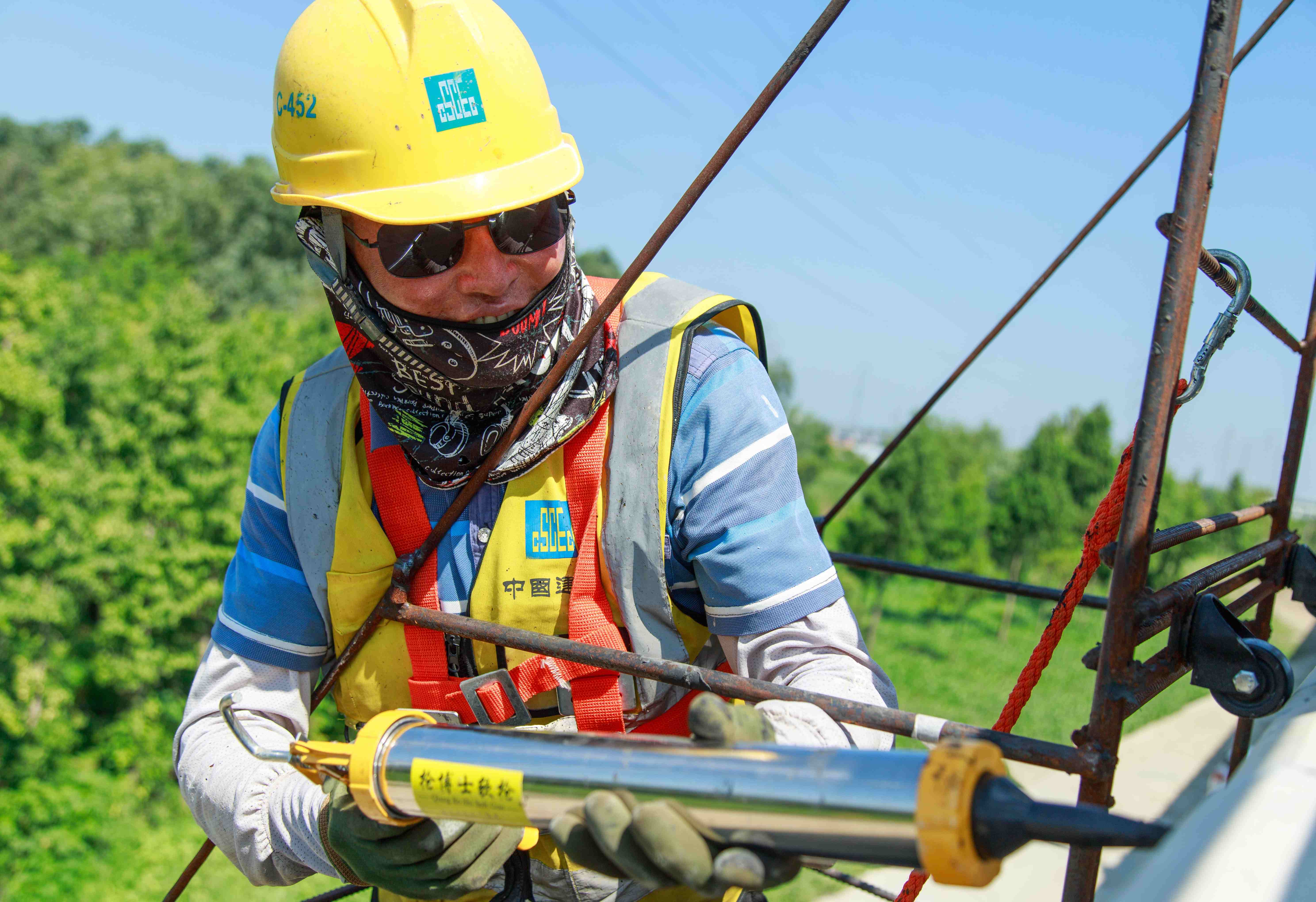 彭林，60歲，江蘇射陽人，204國道鹽阜快速通道YFTH1標(biāo)工人，正在冒著高溫給高架橋護(hù)欄伸縮縫打膠。通車在即，他希望把工程弄得漂漂亮亮。.jpg